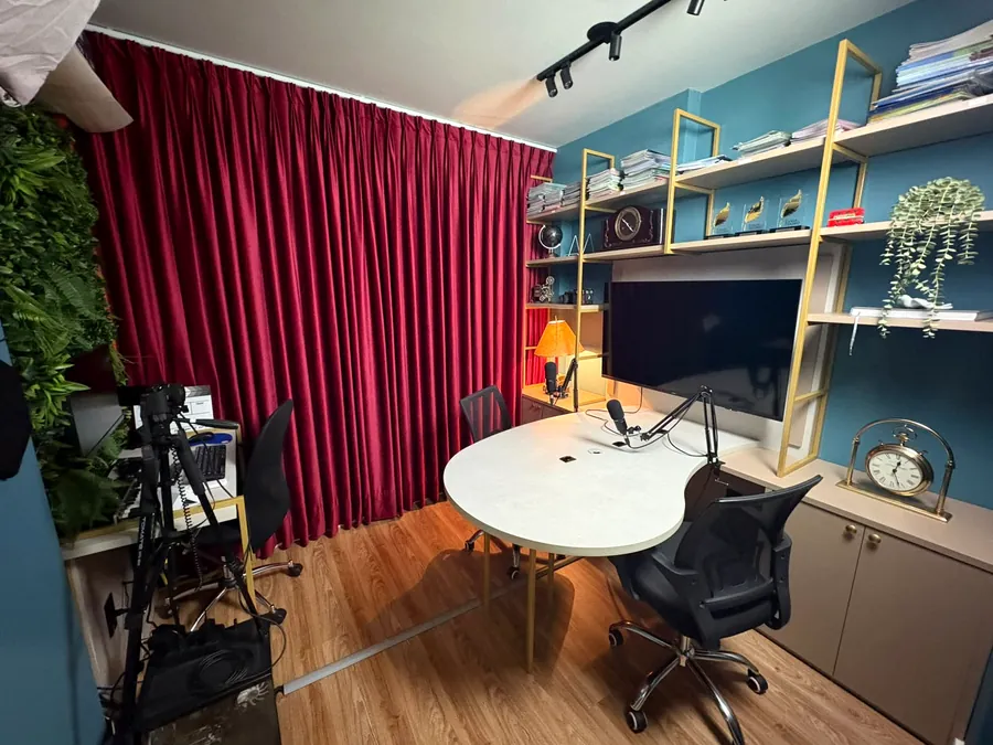 Estúdio de podcast com mesa orgânica, microfones e cortina bordô